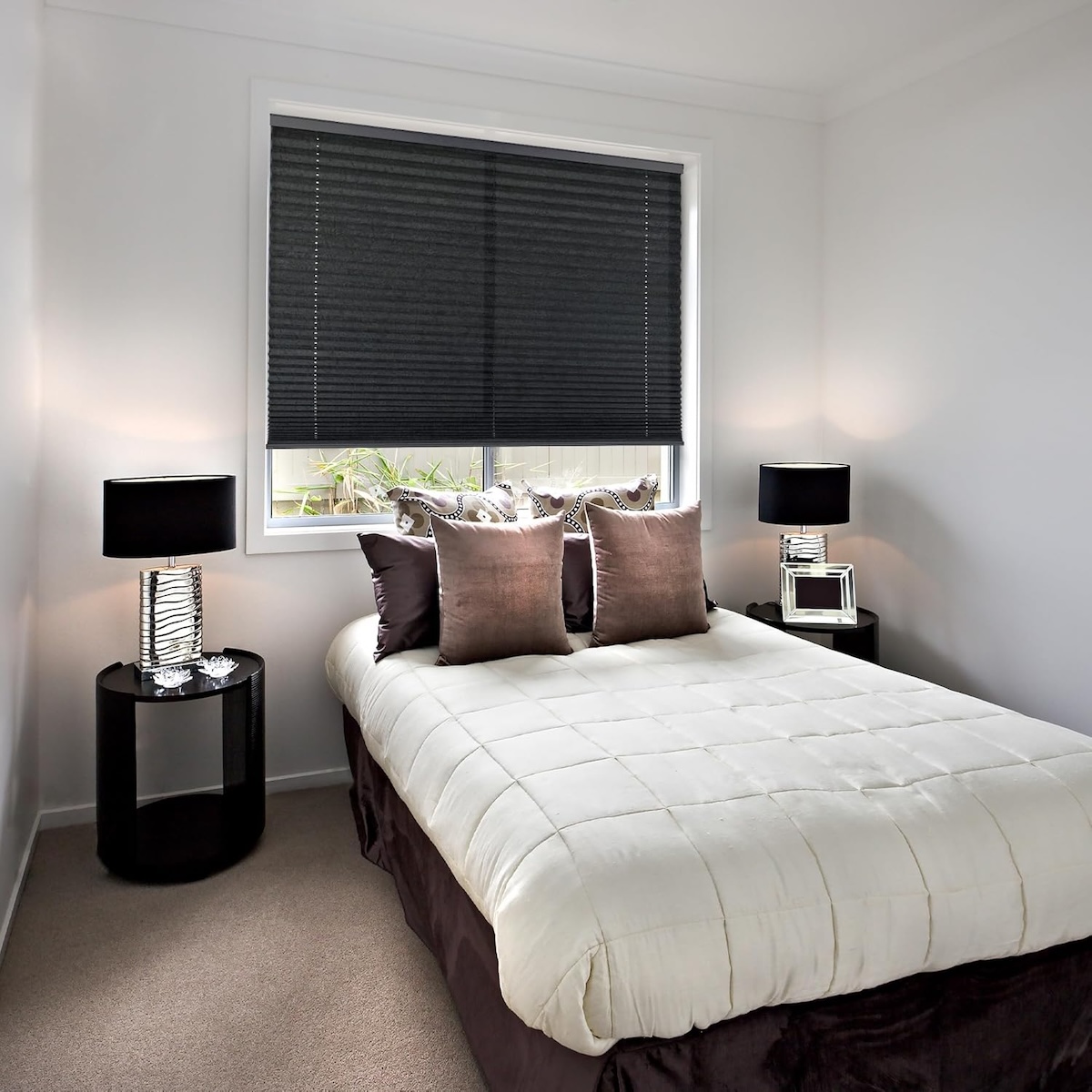 Black pleated blinds hanging on a window in a modern bedroom.